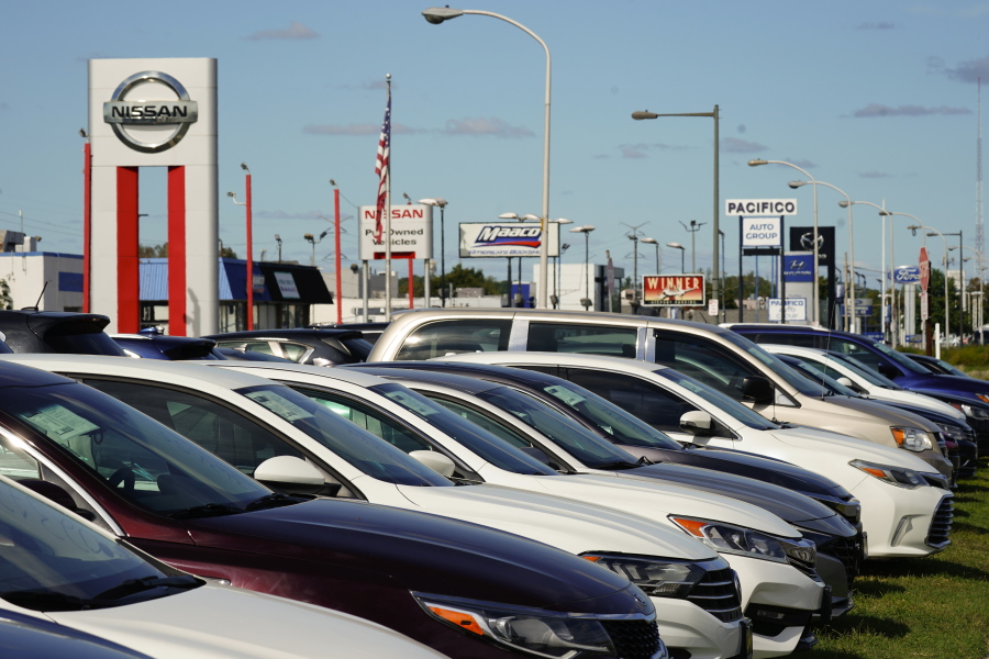 FILE - Cars for sale line the road at a used auto dealership in Philadelphia, Thursday, Sept. 29, 2022. The prices of new and used vehicles in the United States have begun inching down from their eye-watering record highs as more vehicles have become gradually available at dealerships.