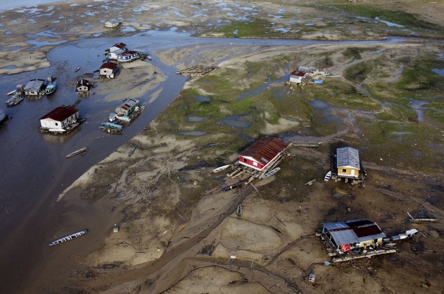 Houseboats sit amid drought-impacted land near the Solim?es River, in Tefe, Amazonas state, Brazil, Wednesday, Oct. 19, 2022. Months after enduring floods that destroyed crops, thousands of families in the Brazilian Amazon are now dealing with severe drought.