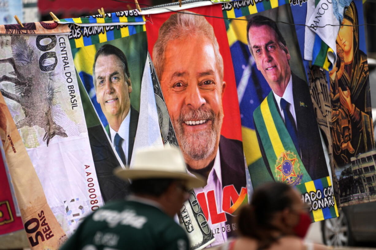 FILE - Towels with images of Brazilian presidential candidates, President Jair Bolsonaro and former President Luiz Inacio Lula da Silva, are for sale by a street vendor, hanging from a makeshift clothesline in Brasilia, Brazil, Thursday, Sept. 22, 2022. Despite the smoke clogging the air of entire Amazon cities, state elections have largely ignored environmental issues.