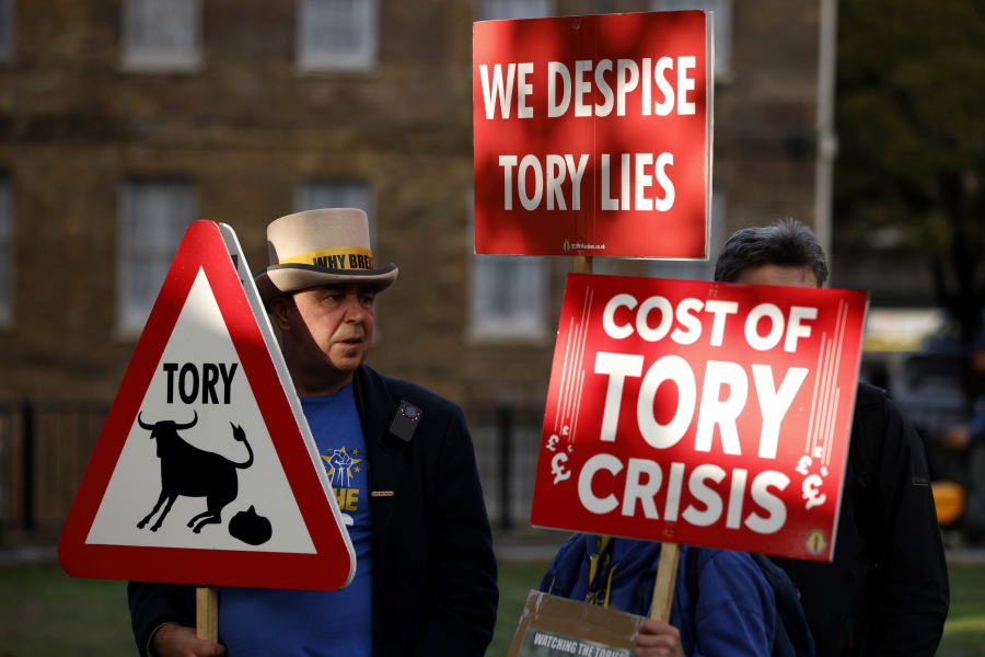 Demonstrators protest opposite parliament after Britain's Prime Minister Liz Truss resigned in London, Thursday, Oct. 20, 2022.