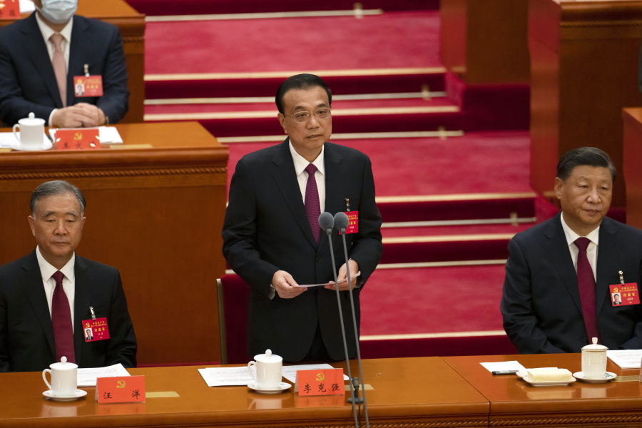 Chinese Premier Li Keqiang is flanked by Politburo Standing Committee member Wang Yang, left, and President Xi Jinping as he speaks during the opening ceremony of the 20th National Congress of China's ruling Communist Party at the Great Hall of the People in Beijing, China, Sunday, Oct. 16, 2022. While Xi is primed to receive a third five-year term as head of China's ruling Communist Party at this week's congress, new members of the party's leading bodies are expected to be appointed at the meeting, whose proceedings are mainly held behind closed doors.