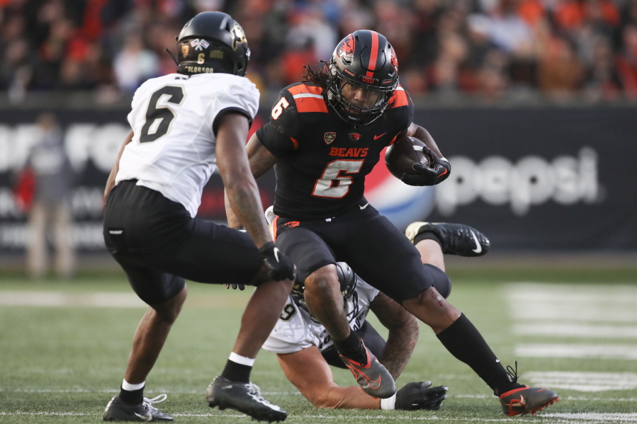 Oregon State running back Damien Martinez, front right, dodges Colorado cornerback Nikko Reed, front left, during the first half of an NCAA college football game on Saturday, Oct. 22, 2022, in Corvallis, Ore.