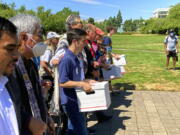 FILE - Backers of a proposed initiative that would require individuals to secure permits to buy firearms and ban large-capacity magazines deliver the signatures of thousands of voters on July 8, 2022, to state election offices in Salem, Ore.