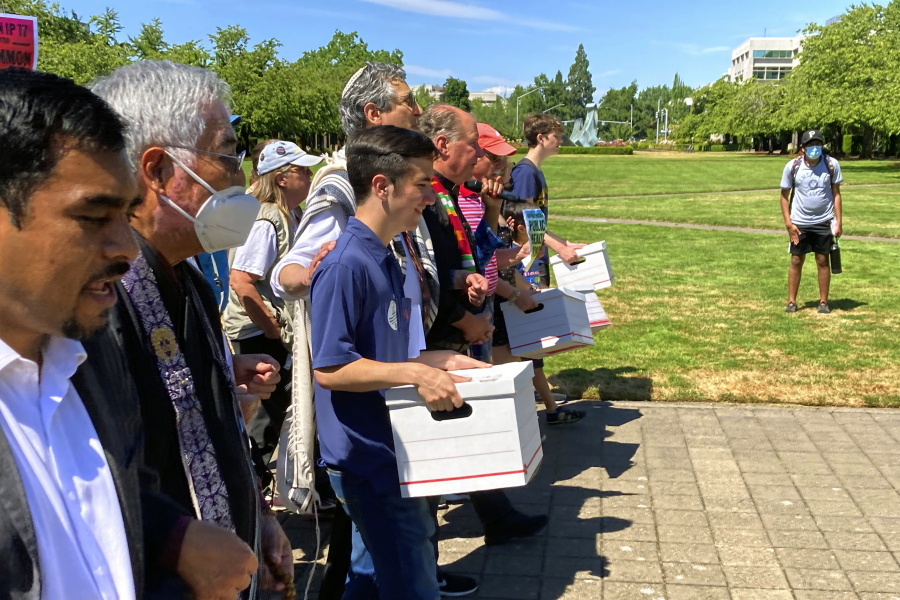 FILE - Backers of a proposed initiative that would require individuals to secure permits to buy firearms and ban large-capacity magazines deliver the signatures of thousands of voters on July 8, 2022, to state election offices in Salem, Ore.