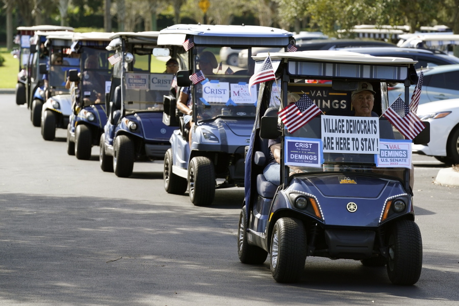 A caravan of golf carts head to a polling place to take part in early voting after a campaign event for Rep. Val Demings, D-Fla., candidate for U.S. Senate, Monday, Oct. 17, 2022, in The Villages, Fla.
