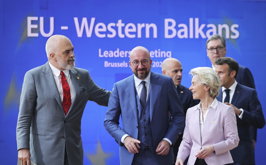 FILE - From left, Albanian Prime Minister Edi Rama, European Council President Charles Michel, North Macedonia's Prime Minister Dimitar Kovacevski, European Commission President Ursula von der Leyen, Serbian President Aleksandar Vucic and French President Emmanuel Macron walk to a group photo during an EU summit in Brussels, on June 23, 2022. The European Union is in the midst of yet another goodwill trip through the neighboring Western Balkans in its drive to drum up support for the bloc and to make sure that the historical tinderbox is not about to pick the side of hostile Russia or strategic rival China in the geopolitical fight.