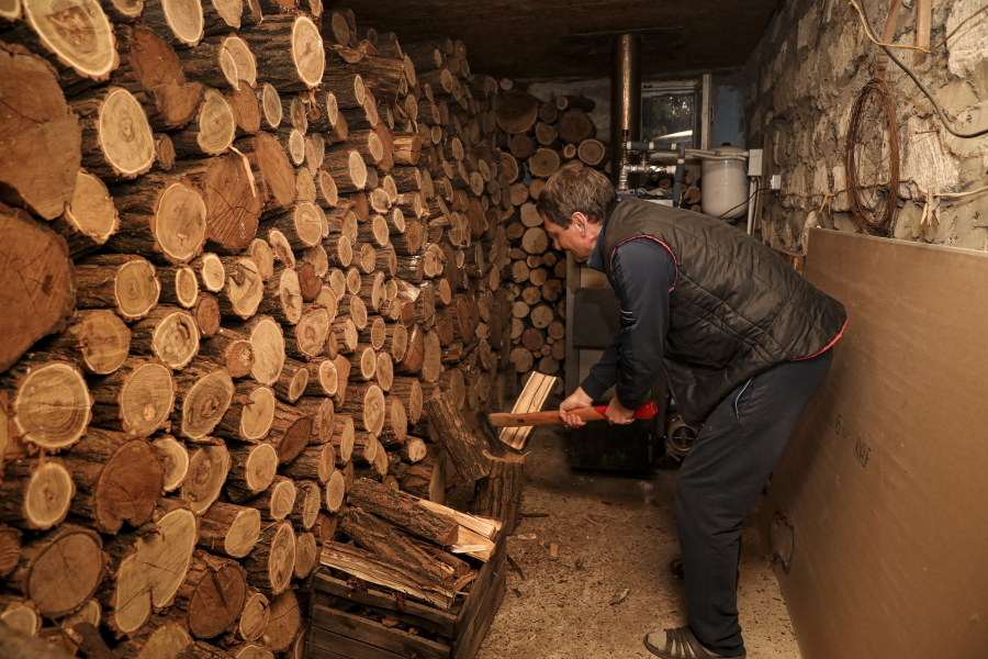 Tudor Popescu chops wood that he uses for heating Oct. 15 in a storage room attached to his home in Chisinau, Moldova.