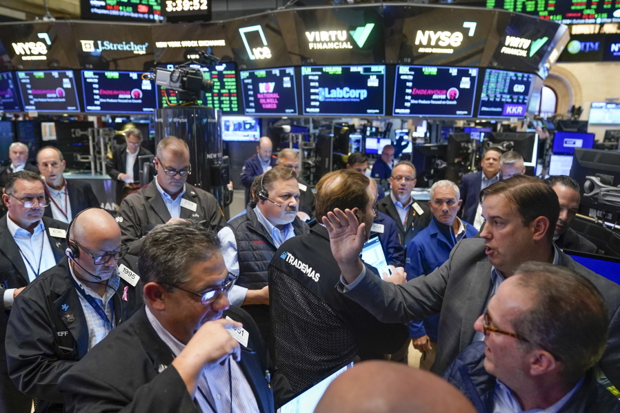 Traders gather around a post as Twitter shares resume trading on the floor at the New York Stock Exchange in New York, Tuesday, Oct. 4, 2022.