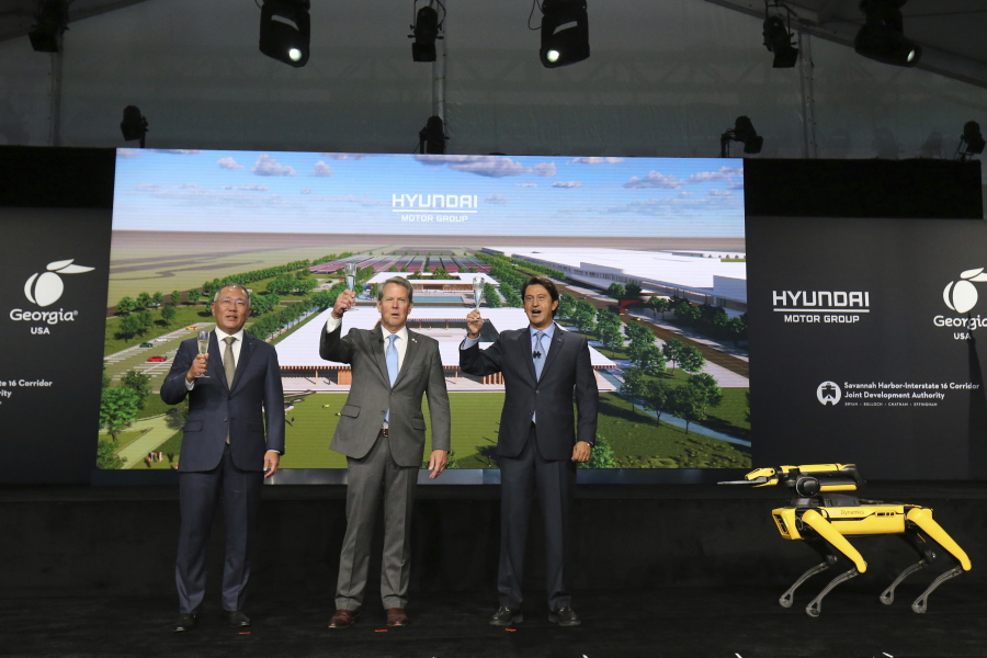 Chung Eui-sun, left, executive chairman of Hyundai Motor Group, Georgia Gov. Brian Kemp, and Jose Munoz, president and COO of Hyundai, celebrate with a champagne toast during the official groundbreaking for the Hyundai Meta Plant on Tuesday, Oct. 25, 2022 in Ellabell, Ga.
