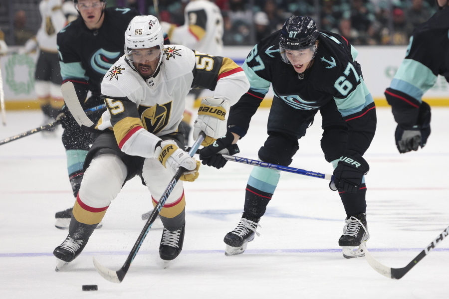 Vegas Golden Knights right wing Keegan Kolesar (55) carries the puck as Seattle Kraken center Morgan Geekie defends during the first period of an NHL hockey game, Saturday, Oct. 15, 2022, in Seattle.