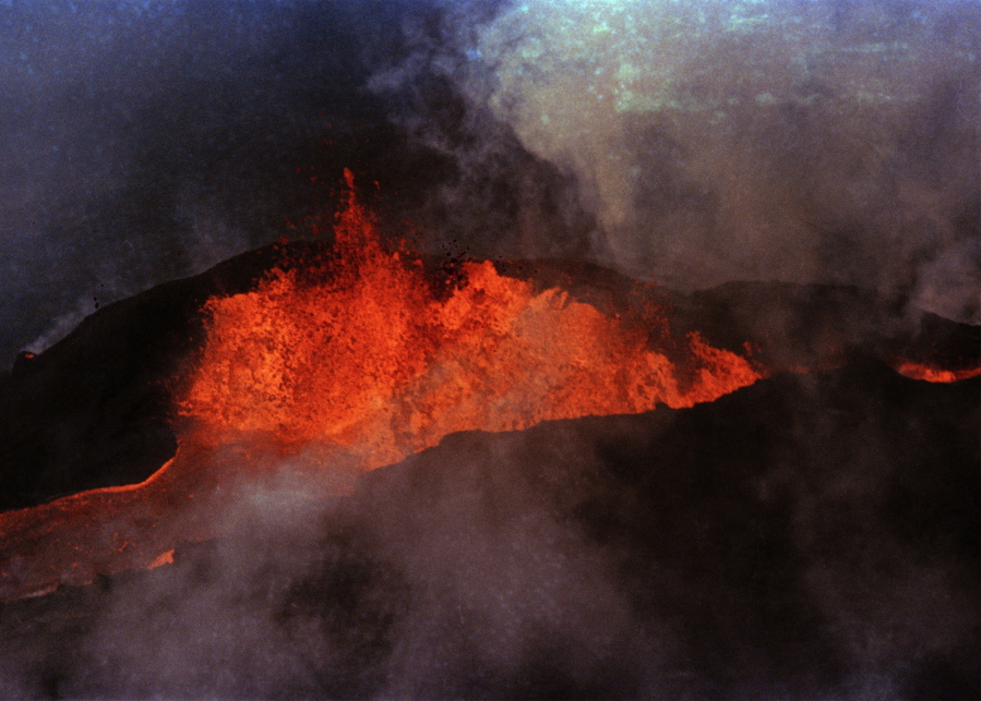 FILE - Molten rock flows from Mauna Loa on March 28, 1984, near Hilo, Hawaii. Hawaii officials are warning residents of the Big Island to prepare for the possibility that the world's largest active volcano may erupt given a recent spike in earthquakes at the summit of Mauna Loa. Scientists don't expect the volcano to erupt imminently, but officials are reminding people lava could reach some homes in just a few hours when it does.