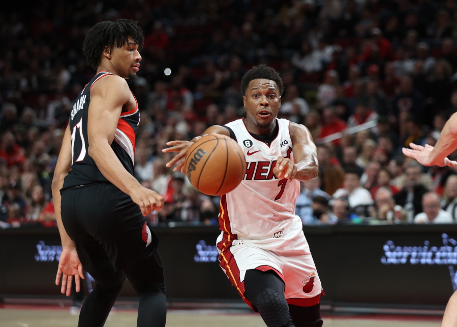 Miami Heat guard Kyle Lowry, right, passes the ball as Portland Trail Blazers guard Shaedon Sharpe, left defends during the first half of an NBA basketball game in Portland, Ore., Wednesday, Oct. 26, 2022.