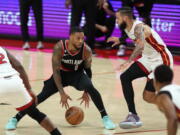 Portland Trail Blazers guard Damian Lillard, left, looks to drive past Miami Heat forward Caleb Martin, right, during the second half of an NBA basketball game in Portland, Ore., Wednesday, Oct. 26, 2022.