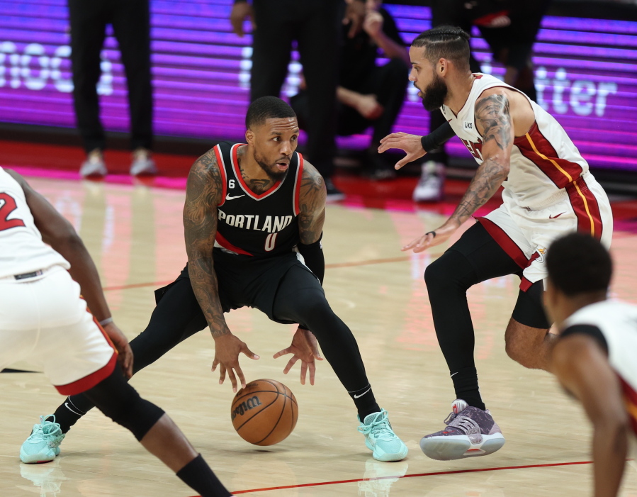 Portland Trail Blazers guard Damian Lillard, left, looks to drive past Miami Heat forward Caleb Martin, right, during the second half of an NBA basketball game in Portland, Ore., Wednesday, Oct. 26, 2022.