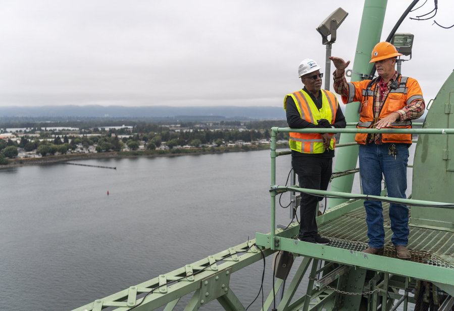 Interstate 5 Bridge Supervisor Marc Gross, right, and Interstate Bridge Replacement Program Administrator Greg Johnson talk Oct. 5 atop one of the Interstate 5 Bridge's lift towers. Johnson and his family were forced to move so a highway could be built on the homes' land. Johnson, who was in kindergarten, thought the moves were fun, but his siblings struggled with it. Two of his five siblings were held back a grade.
