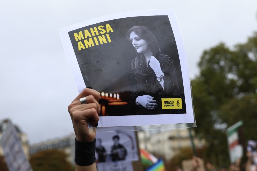 FILE - A protester shows a portrait of Mahsa Amini during a demonstration to support Iranian protesters standing up to their leadership over the death of a young woman in police custody, Sunday, Oct. 2, 2022 in Paris.  Anti-government demonstrations erupted Saturday, Oct. 8,  in several locations across Iran as the most sustained protests in years against a deeply entrenched theocracy entered their fourth week. The protests erupted Sept. 17, after the burial of 22-year-old Amini, a Kurdish woman who had died in the custody of Iran's feared morality police.