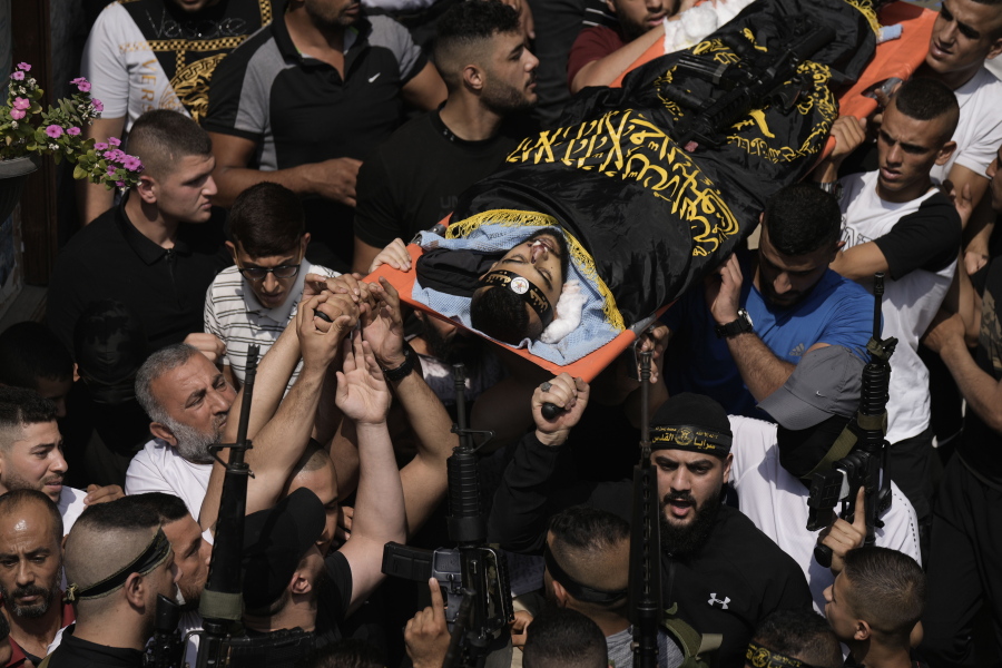 Mourners carry the body of Matin Dababa at his funeral in the Jenin refugee camp, Friday, Oct. 14, 2022. The Palestinian Health Ministry says the Israeli military shot and killed two Palestinians, including Dababa, during a raid into the Jenin refugee camp in the occupied West Bank.