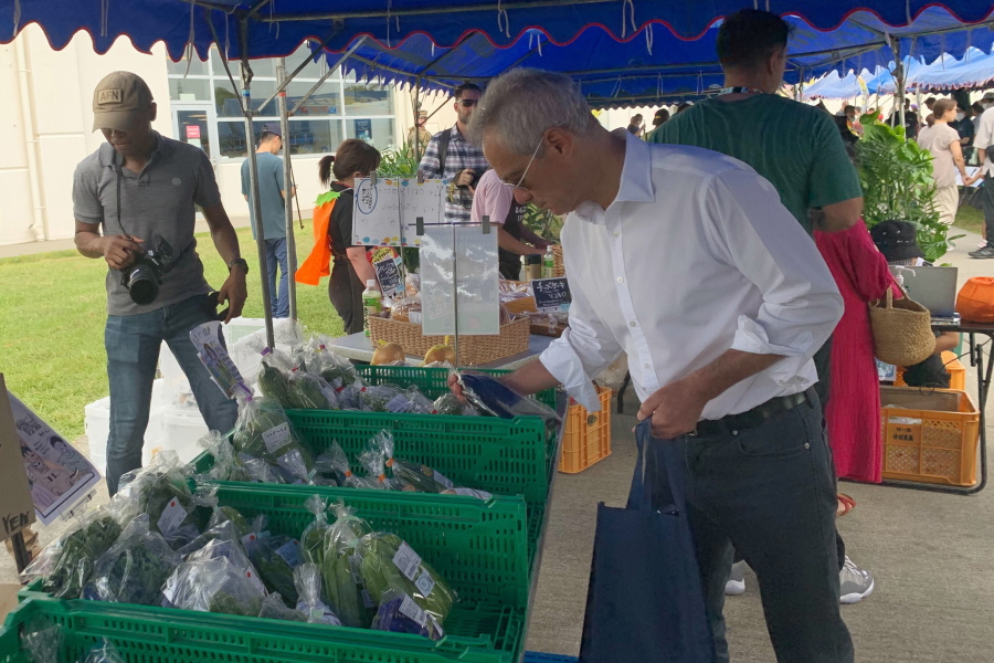 U.S. Ambassador to Japan Rahm Emanuel looks at vegetables at the farmers market at Camp Hansen, a U.S. Marine Corps base on a southern Japanese island of Okinawa, Sunday, Oct. 30, 2022. (U.S.