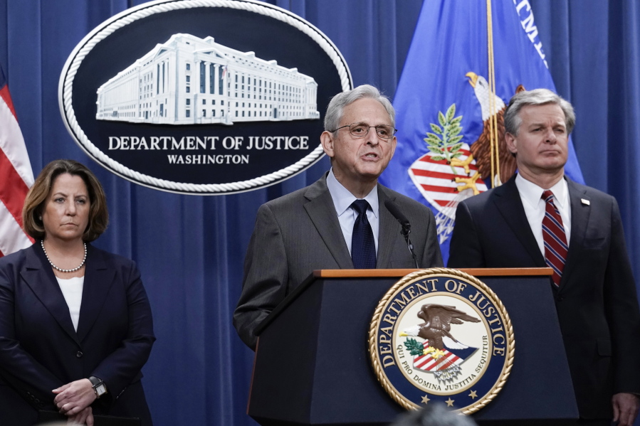 Attorney General Merrick Garland, center, flanked by Deputy Attorney General Lisa Monaco, left, and FBI Director Christopher Wray, speaks to reporters as they announce charges against two men suspected of being Chinese intelligence officers for attempting to obstruct a U.S. criminal investigation and prosecution of Chinese tech giant Huawei, at the Department of Justice in Washington, Monday, Oct. 23, 2022. (AP Photo/J.
