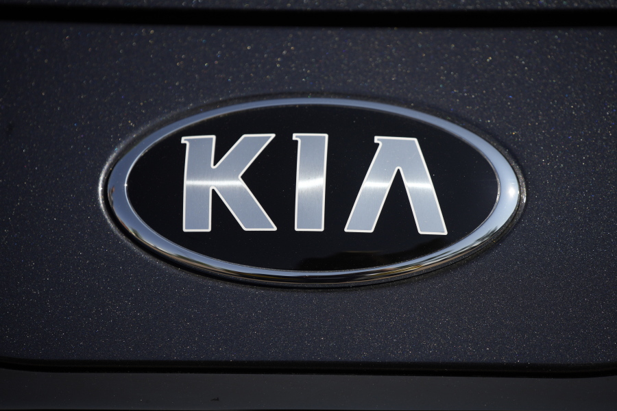 FILE - The company logo shines off the hood of a 2021 K5 sedan on display in the Kia exhibit at the Denver auto show Friday, Sept. 17, 2021, at Elitch's Gardens in downtown Denver.  Kia is telling owners, Wednesday, Oct. 26, 2022, of nearly 72,000 older Sportage small SUVs in the U.S. to park them outdoors and away from structures after getting reports of more engine fires. It's the second time that Sportages from the 2008 and 2009 model years have been recalled due to fire risks that apparently can start near a hydraulic engine control device.