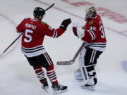 Chicago Blackhawks defenseman Connor Murphy, left, celebrates with goaltender Alex Stalock after they defeated the Seattle Kraken in an NHL hockey game in Chicago, Sunday, Oct. 23, 2022. (AP Photo/Nam Y.
