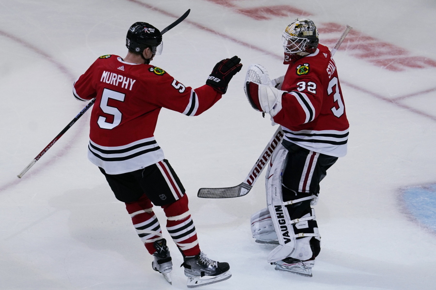 Chicago Blackhawks defenseman Connor Murphy, left, celebrates with goaltender Alex Stalock after they defeated the Seattle Kraken in an NHL hockey game in Chicago, Sunday, Oct. 23, 2022. (AP Photo/Nam Y.