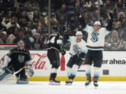 Seattle Kraken left wing Brandon Tanev, right, celebrates his goal with right wing Jordan Eberle, second from left, as Los Angeles Kings goaltender Jonathan Quick, left, kneels in the crease and defenseman Mikey Anderson skates away during the second period of an NHL hockey game Thursday, Oct. 13, 2022, in Los Angeles. (AP Photo/Mark J.