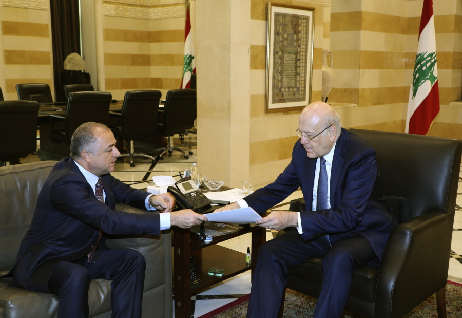 In this photo released by Lebanon's official government photographer Dalati Nohra, Lebanese Prime Minister Najib Makati, right, receives the final draft of the maritime border agreement between Lebanon and Israel from his deputy Elias Bou Saab who leads the Lebanese negotiating team, in Beirut, Lebanon, Tuesday, Oct. 11, 2022. Israel's prime minister said Tuesday that the country has reached an "historic agreement" with neighboring Lebanon over their shared maritime border after months of U.S.-brokered negotiations.