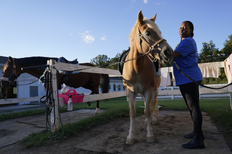 Dionne Williamson, of Patuxent River, Md., grooms Woody before her riding lesson at Cloverleaf Equine Center in Clifton, Va., Tuesday, Sept. 13, 2022. After finishing a tour in Afghanistan in 2013, Williamson felt emotionally numb. As the Pentagon seeks to confront spiraling suicide rates in the military ranks, Williamson's experiences shine a light on the realities for service members seeking mental health help.