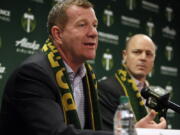 FILE - Portland Timbers team president and general manager Gavin Wilkinson, left, speaks as team owner Merritt Paulson, right, listens during an MLS soccer news conference on Jan. 8, 2018, in Portland, Ore. Wilkinson and Paulson have been removed from any decision-making roles with the Portland Thorn's National Women's Soccer League club until the findings are released from an ongoing investigation into numerous scandals around the league.