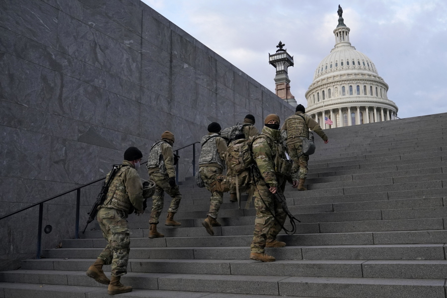 FILE - National Guard members take a staircase toward the U.S. Capitol building before a rehearsal for President-elect Joe Biden's Presidential Inauguration in Washington, Jan. 18, 2021. Soldiers are leaving the Army National Guard at a faster rate than they are enlisting, fueling concerns that in the coming years units around the country may not meet military requirements for overseas and other deployments. Officials say the number of soldiers retiring or leaving the Guard each month in the past year has exceeded those coming in, for a total annual loss of about 7,500 service members.