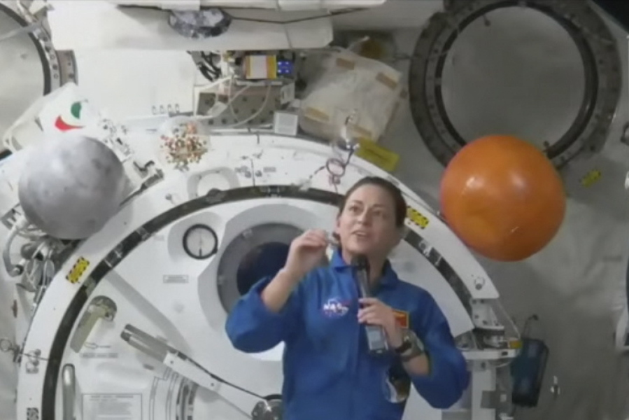 In this image from video made available by NASA, astronaut Nicole Mann shows her dreamcatcher during an interview on Wednesday, Oct. 19, 2022. The first Native American woman in space said Wednesday that she's overwhelmed by the beauty and delicacy of Mother Earth, and is channeling "positive energy" as her five-month mission gets underway.