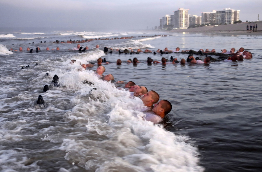 FILE - U.S. Navy SEAL candidates, participate in "surf immersion" during Basic Underwater Demolition/SEAL (BUD/S) training at the Naval Special Warfare (NSW) Center in Coronado, Calif., on May 4, 2020. Navy officials and a new report say the Naval Special Warfare Command has reprimanded three officers in connection with the February 2022 death of SEAL candidate Kyle Mullen, who collapsed and died of acute pneumonia just hours after completing the grueling Hell Week test. (MC1 Anthony Walker/U.S.