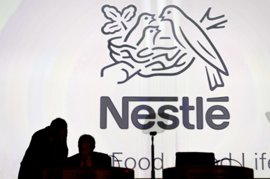 FILE - In this April 7, 2016, file photo Nestle's directors speak in front of the Nestle's logo during the general meeting of Nestle Group, in Lausanne, Switzerland. Starbucks is selling its Seattle's Best Coffee brand to Nestle for an undisclosed amount. Switzerland-based Nestle has been in a partnership with Seattle-based Starbucks since 2018 and already distributes Starbucks-branded coffee in more than 80 markets worldwide.