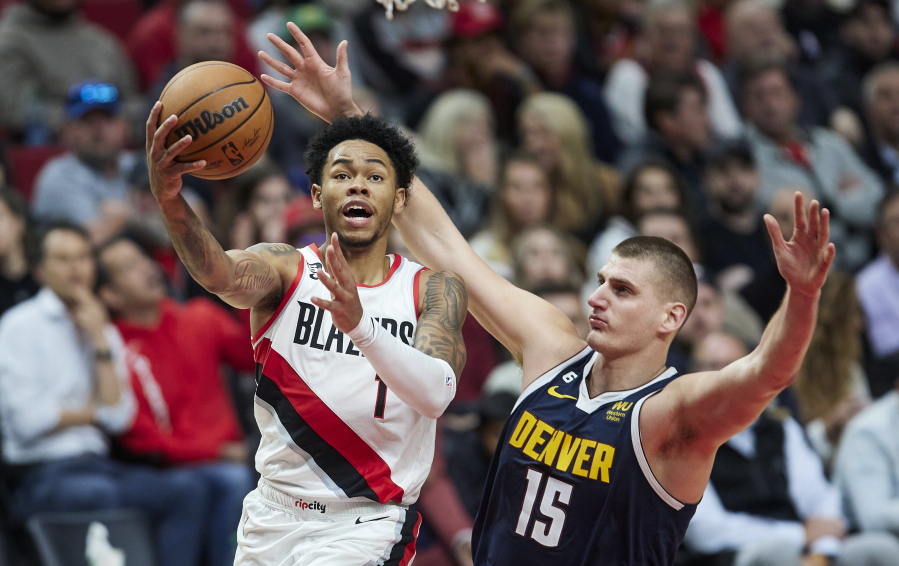 Portland Trail Blazers guard Anfernee Simons, left, shoots over Denver Nuggets center Nikola Jokic during the second half of an NBA basketball game in Portland, Ore., Monday, Oct. 24, 2022.