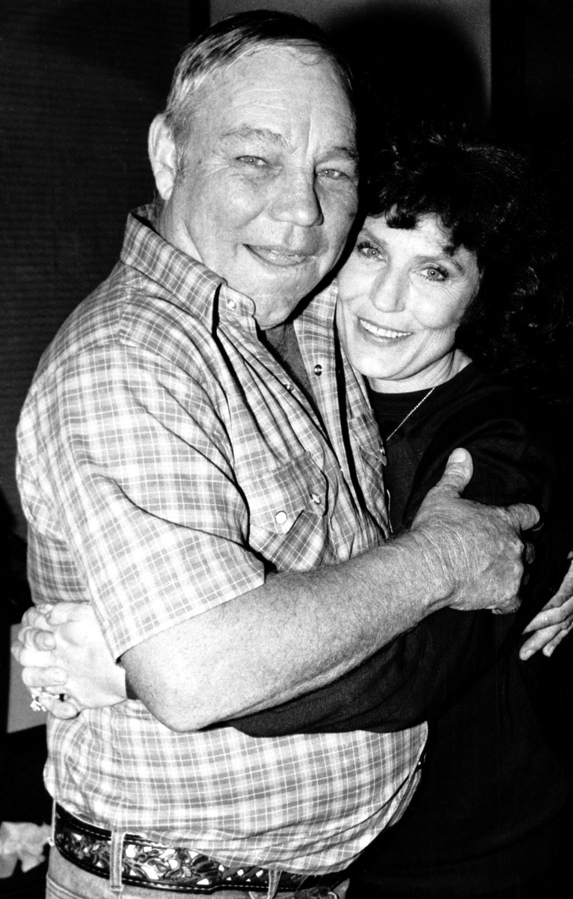 FILE - Country music singer Loretta Lynn embraces her husband, Oliver "Mooney" Lynn, during rehearsal for her New York debut, on Oct. 21, 1982.  Lynn, the Kentucky coal miner's daughter who became a pillar of country music, died Tuesday at her home in Hurricane Mills, Tenn. She was 90.