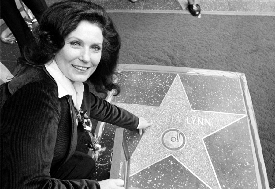 FILE - Country music singer Loretta Lynn points to her Hollywood Walk of Fame star during induction ceremonies in Hollywood, Calif., on Feb. 8, 1978. Lynn, the Kentucky coal miner'??s daughter who became a pillar of country music, died Tuesday at her home in Hurricane Mills, Tenn. She was 90.
