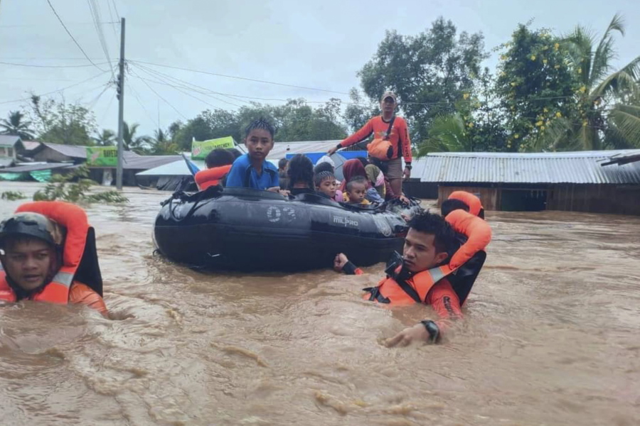In this photo provided by the Philippine Coast Guard, rescuers use boats to evacuate residents from flooded areas due to Tropical Storm Nalgae at Parang, Maguindanao province, southern Philippines on Friday Oct. 28, 2022. Floodwaters rapidly rose in many low-lying villages, forcing some villagers to climb to their roofs, where they were rescued by army troops, police and volunteers, officials said.