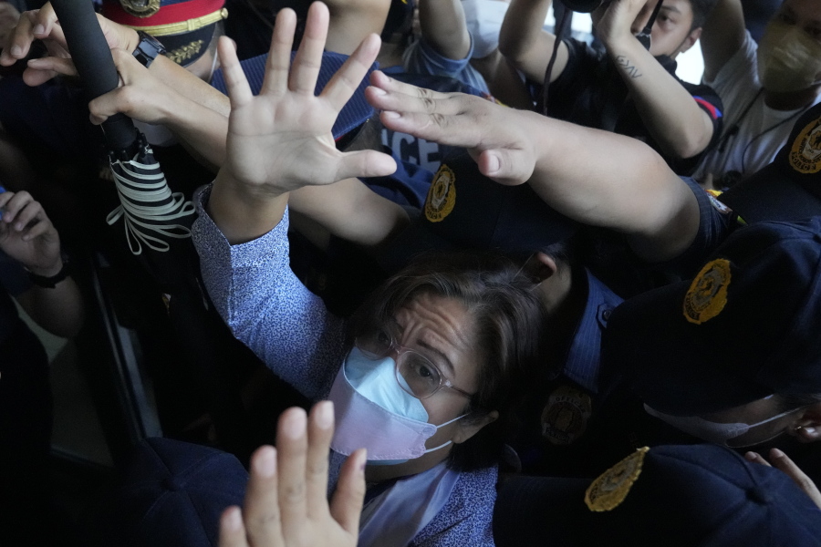 Detained former opposition Sen. Leila de Lima waves under tight security as she arrives to attend a court hearing which later postponed in Muntinlupa, Philippines, Monday, Oct. 10, 2022. Human rights activists pressed their call Monday for the immediate release of de Lima after she was taken hostage in a rampage by three Muslim militants in a failed attempt to escape from a maximum-security jail.