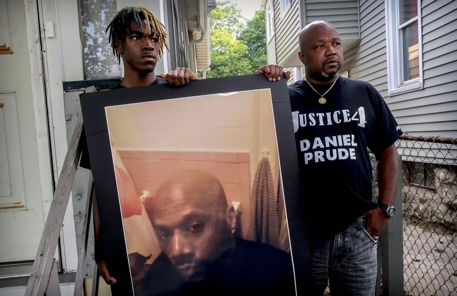 FILE - Armin Prude, left, and Joe Prude hold an enlarged photo of Daniel Prude, Sept. 3, 2020, who died following a police encounter, in Rochester, N.Y. City officials have agreed to pay $12-million to the family of Daniel Prude, a Black man who died after police held him down until he stopped breathing after encountering him running naked through the snowy streets of Rochester, NY. A federal judge approved the settlement in a court document filed Thursday, Oct. 6, 2022.