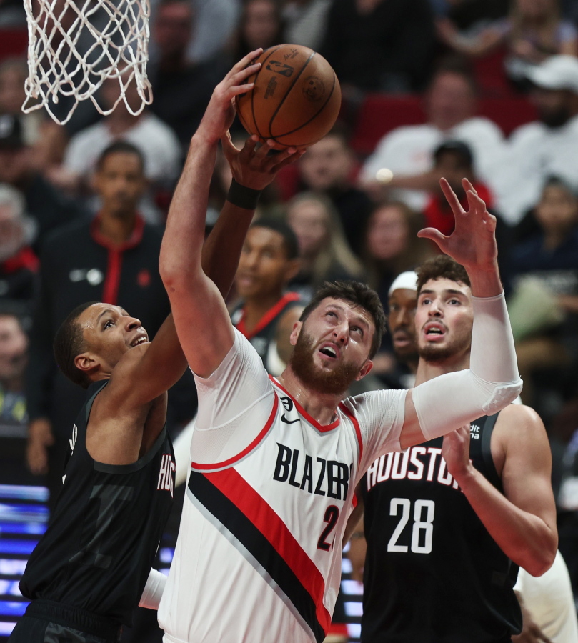 Houston Rockets forward Jabari Smith Jr., left, and Portland Trail Blazers center Jusuf Nurkic, right, battle for a rebound during the first quarter of an NBA basketball game in Portland, Ore., Friday, Oct. 28, 2022.