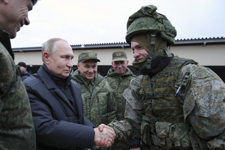 FILE - Russian President Vladimir Putin shakes hands with a soldier as he visits a military training centre of the Western Military District for mobilised reservists as Russian Defense Minister Sergei Shoigu, center, smiles in Ryazan Region, Russia, Thursday, Oct. 20, 2022. The mobilized reservists that Russian President Vladimir Putin visited last week at a firing range southeast of Moscow looked picture-perfect.