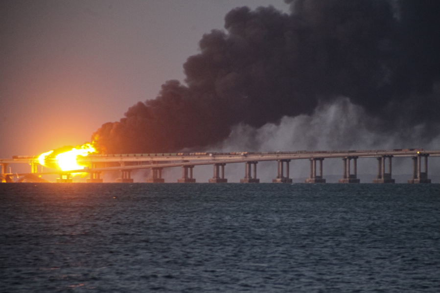 Flame and smoke rise fron Crimean Bridge connecting Russian mainland and Crimean peninsula over the Kerch Strait, in Kerch, Crimea, Saturday, Oct. 8, 2022. Russian authorities say a truck bomb has caused a fire and the partial collapse of a bridge linking Russia-annexed Crimea with Russia. Three people have been killed. The bridge is a key supply artery for Moscow's faltering war effort in southern Ukraine.