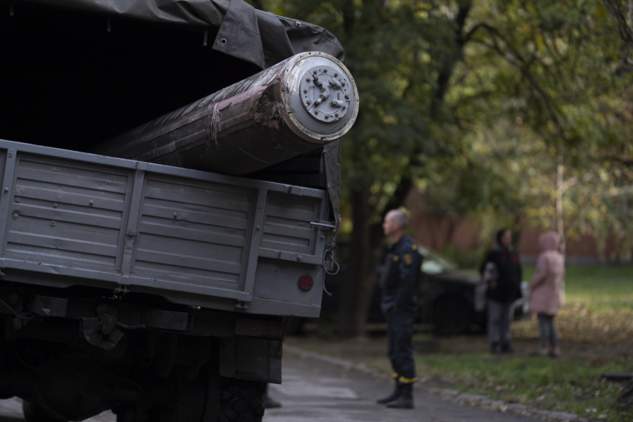 Ukrainian emergency service member stands next to a truck that carries the remains of a missile after a Russian attack in Zaporizhzhia, Ukraine, Friday, Oct. 21, 2022.