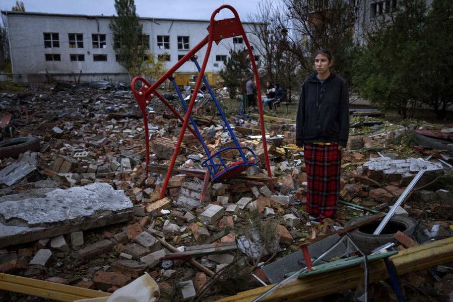 Taisiia Kovaliova, 15, stands amongst the rubble of a playground in front of her house hit by a Russian missile in Mykolaiv, Sunday, Oct. 23, 2022. "I spent all my childhood and life at this courtyard, I already feel nostalgic. I went to this swing that stood it all" Taisiia said.
