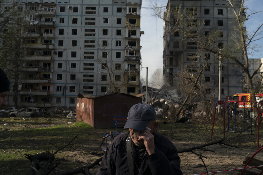 Mucola Markovich, 76, wipes a tear as he stands next to a residential building that was heavily damaged after a Russian attack at a residential area in Zaporizhzhia, Ukraine, Sunday, Oct. 9, 2022.