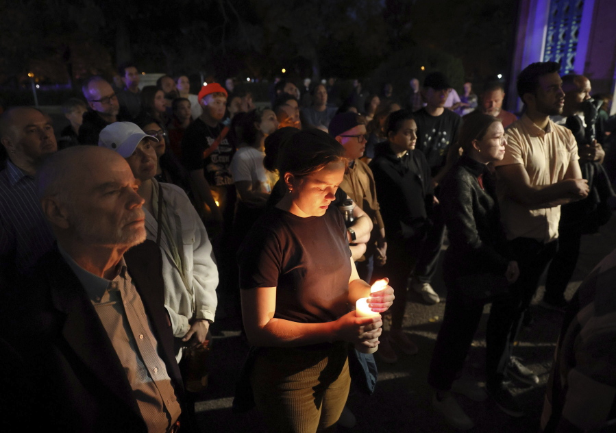 Marie Crane, center, holds a candle during a vigil in Tower Grove Park for the victims of a school shooting at Central Visual & Performing Arts High School in St. Louis on Monday, Oct. 24, 2022. (David Carson/St.