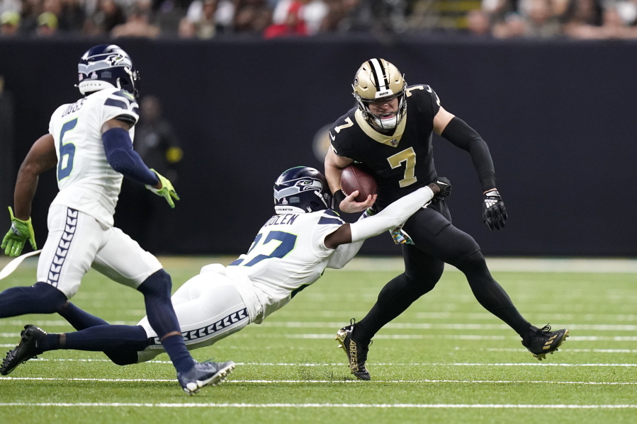 New Orleans Saints' Taysom Hill (7) carries the ball as Seattle Seahawks cornerback Tre Brown tries to make the tackle during an NFL football game in New Orleans, Sunday, Oct. 9, 2022.