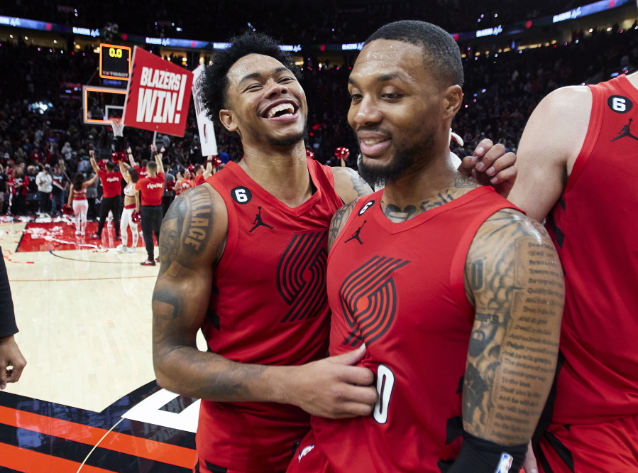 Portland Trail Blazers guard Anfernee Simons, left, and guard Damian Lillard smile after the team's win in an NBA basketball game against the Phoenix Suns in Portland, Ore., Friday, Oct. 21, 2022.