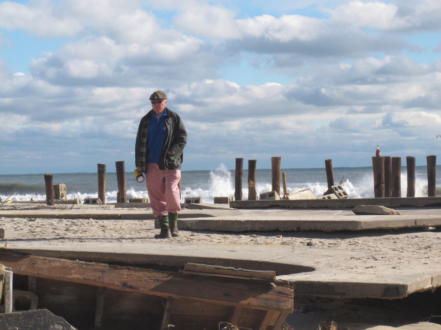 In this Oct. 31, 2012 photo, Peter Green surveys the wreckage of an oceanfront home in Bay Head N.J. two days after Superstorm Sandy hit. Ten years later, government officials and residents say much has been done to prepare for future storms but caution that much more still remains to be done in an era of rising sea levels and a changing climate.